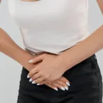 Woman crunched over experiencing pelvic pain in women